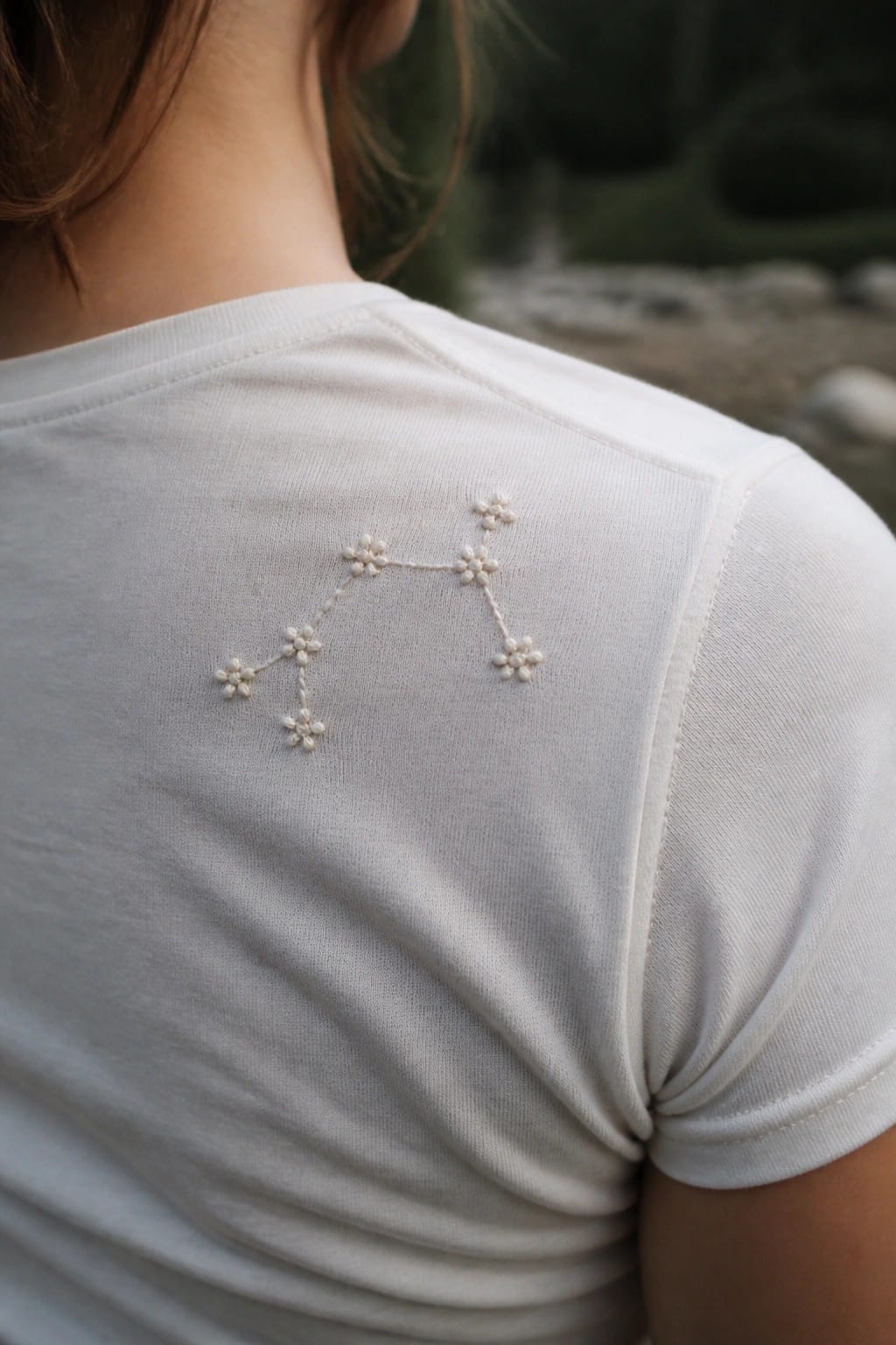 White t-shirt with delicate floral constellation embroidery on shoulder