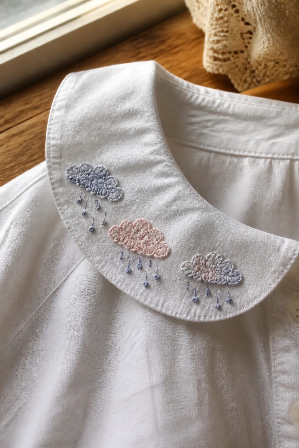 White collared shirt with red cherry embroidery on wooden chair in sunlight