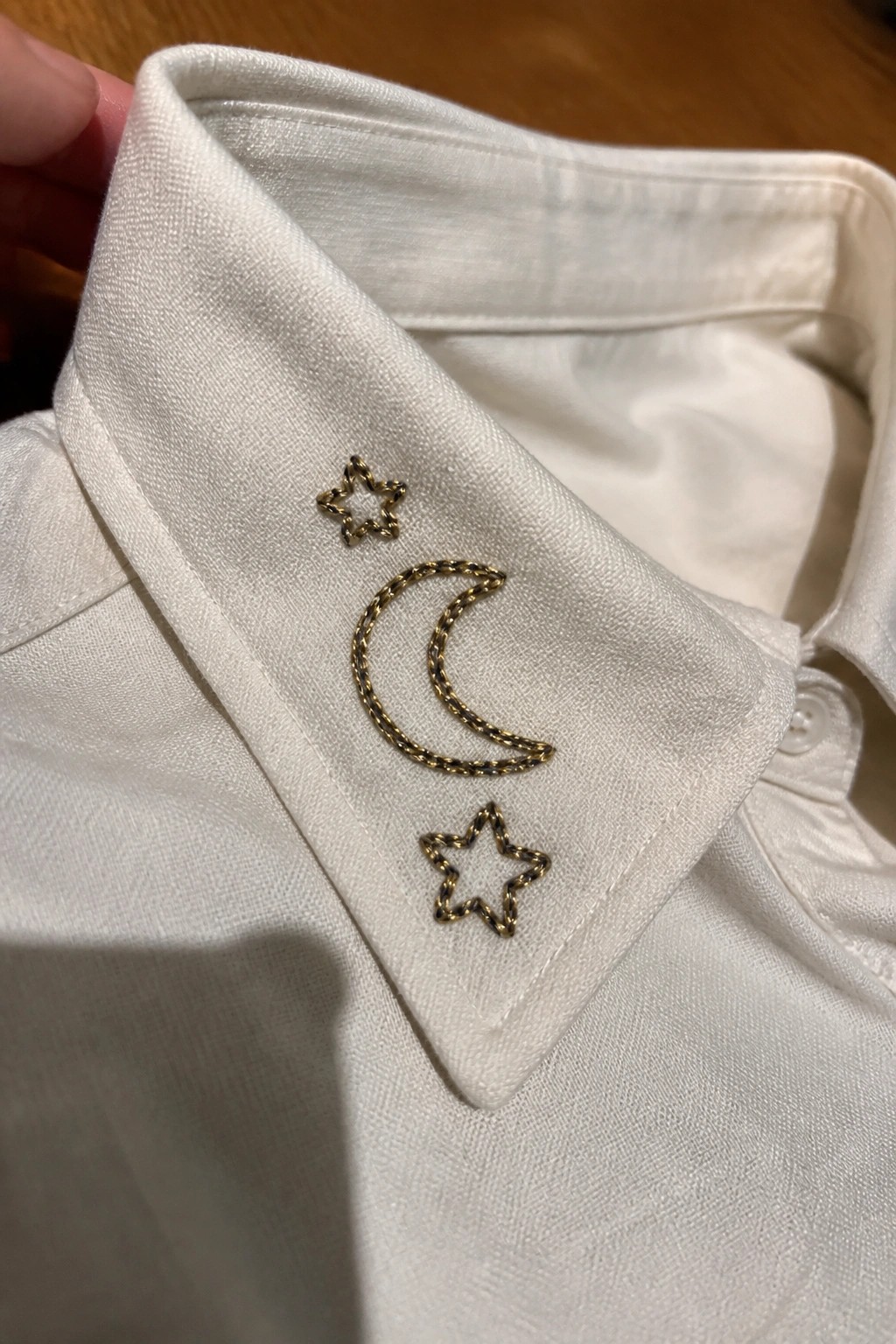 White shirt collar with gold embroidered crescent moon and two stars