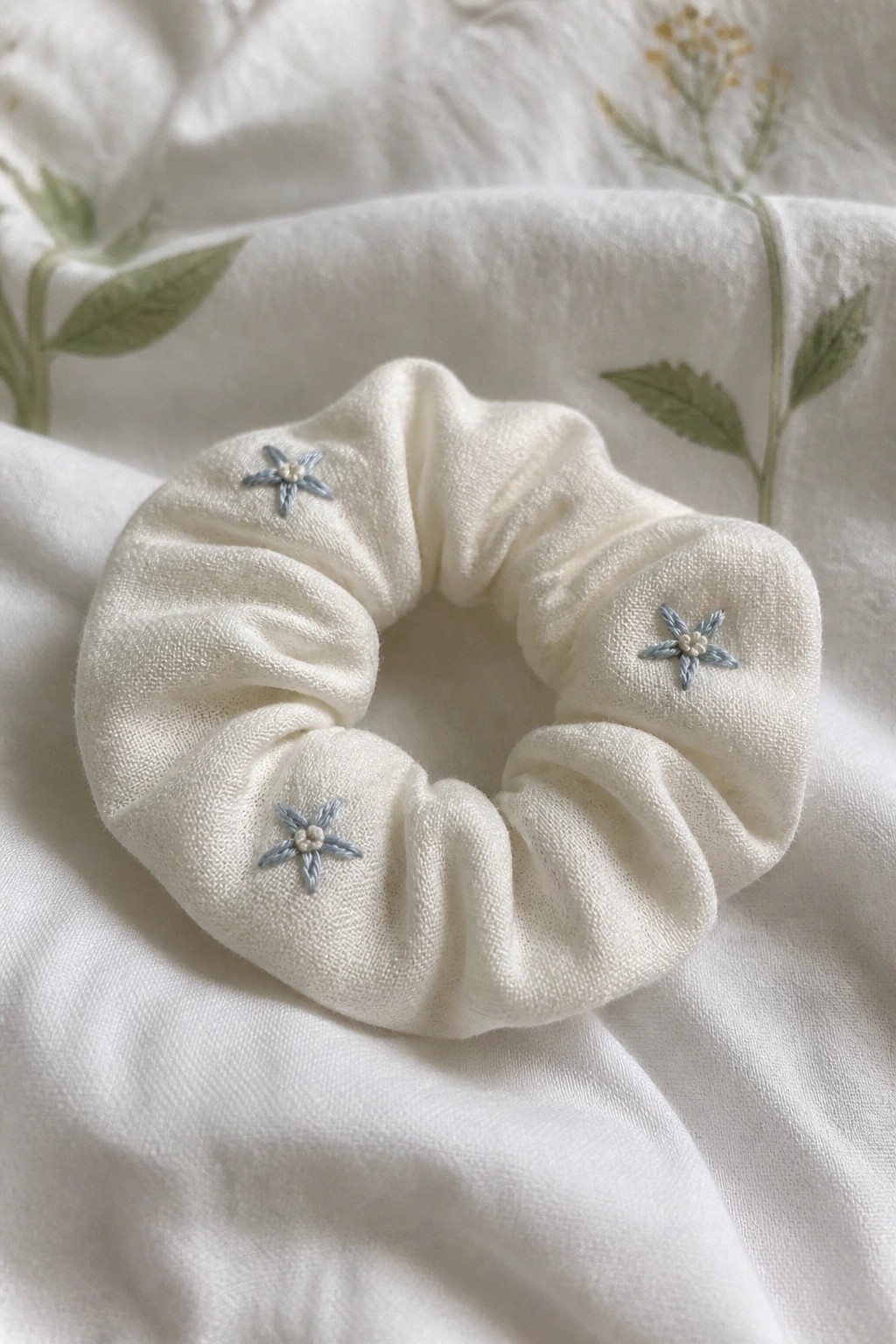 White scrunchie with blue star embroideries on floral white fabric