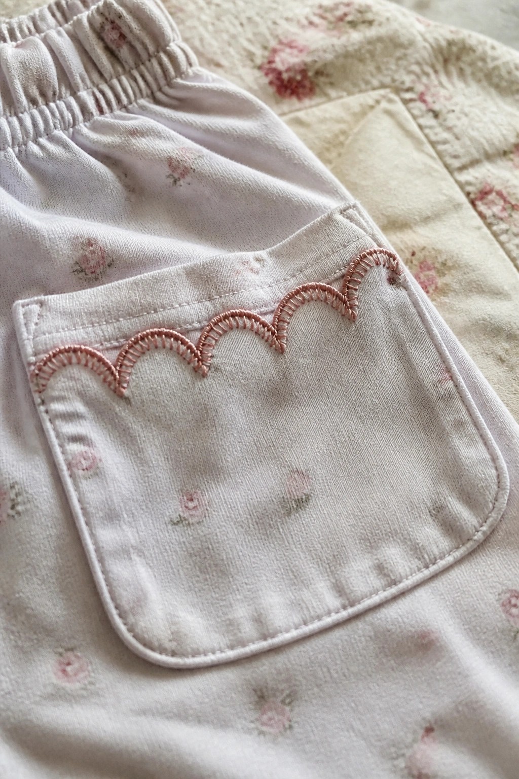 Light pink floral pants with elastic waist and pink scalloped pocket embroidery