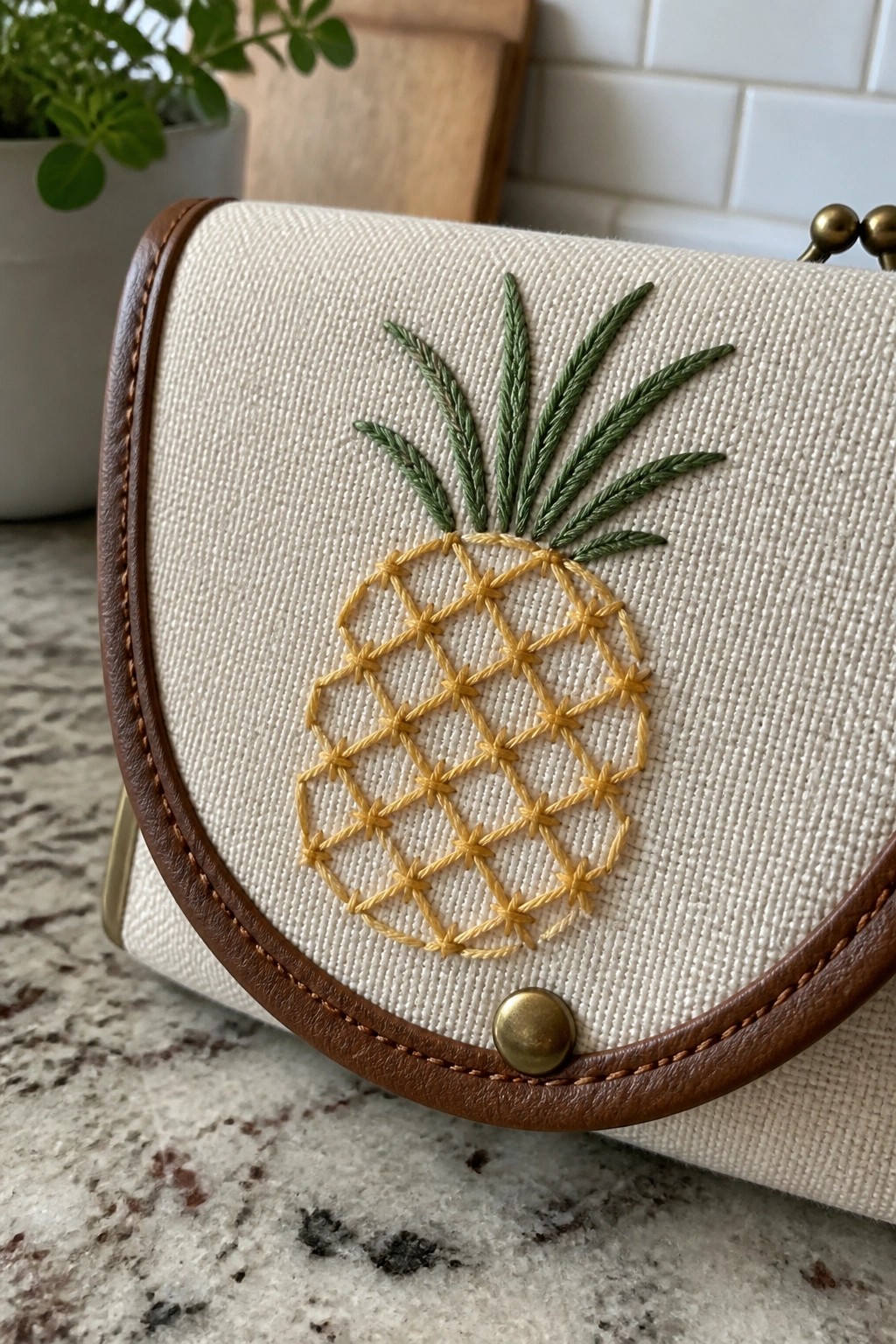 Cream canvas handbag with embroidered yellow pineapple and green leaves on leather trim