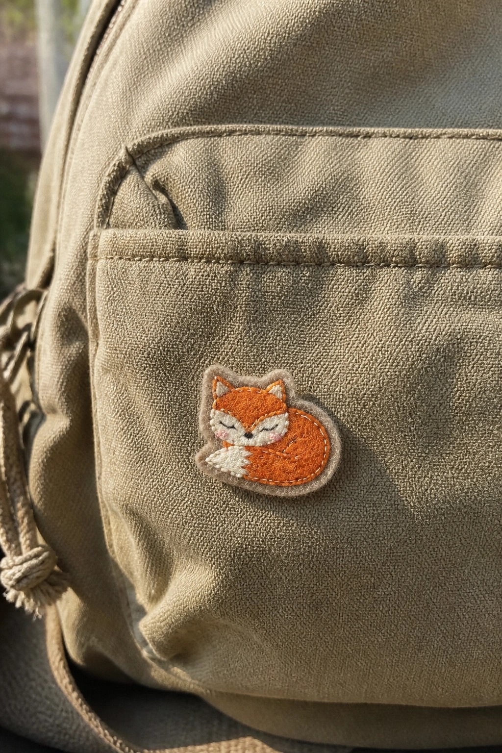 Beige canvas bag with embroidered orange fox patch on front pocket
