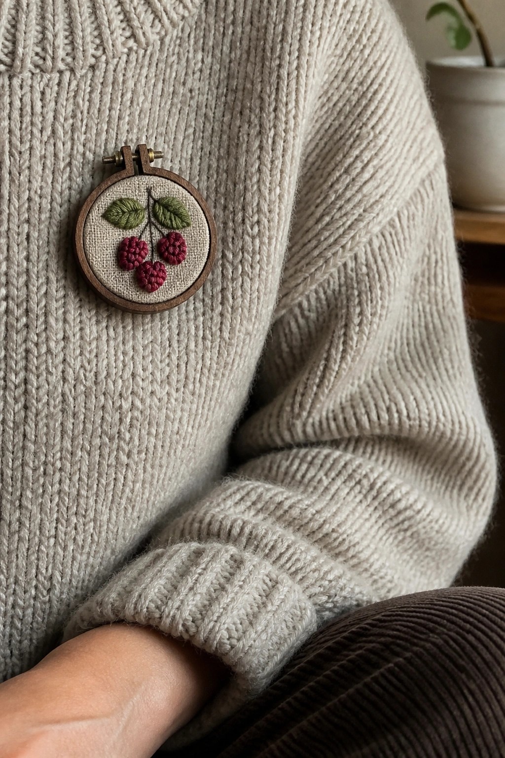 Cream knit sweater with wooden hoop brooch embroidered with red cherries and leaves