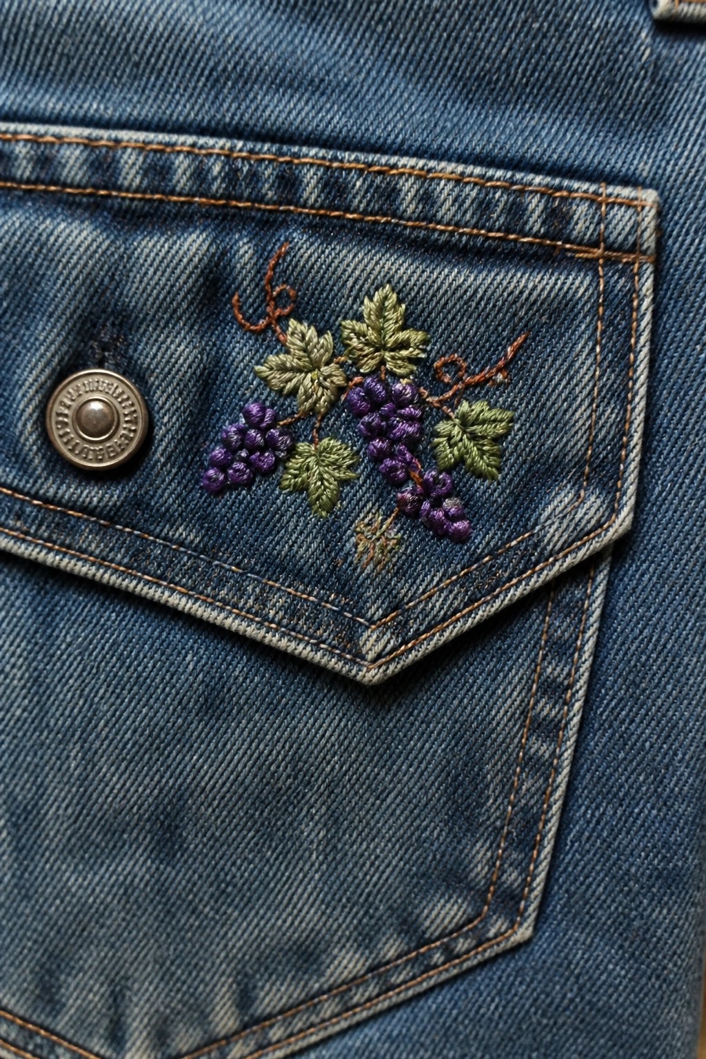 Blue denim jeans pocket with purple grape and green leaf embroidery plus metal button