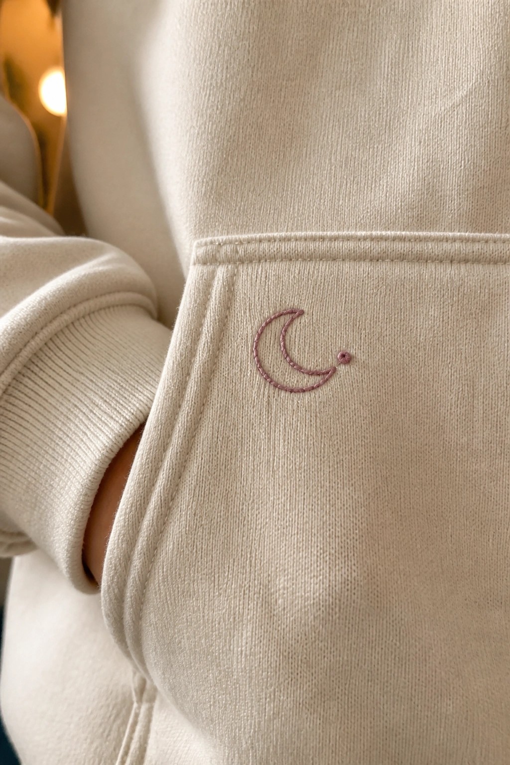 Cream hoodie pocket with pink embroidered crescent moon and dot