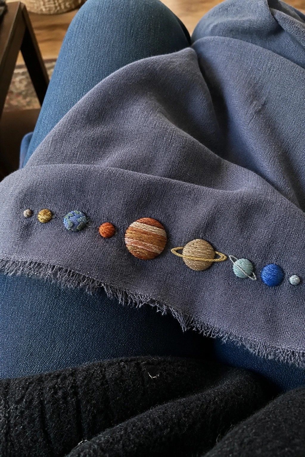 Embroidered solar system planets on frayed blue denim fabric cuff