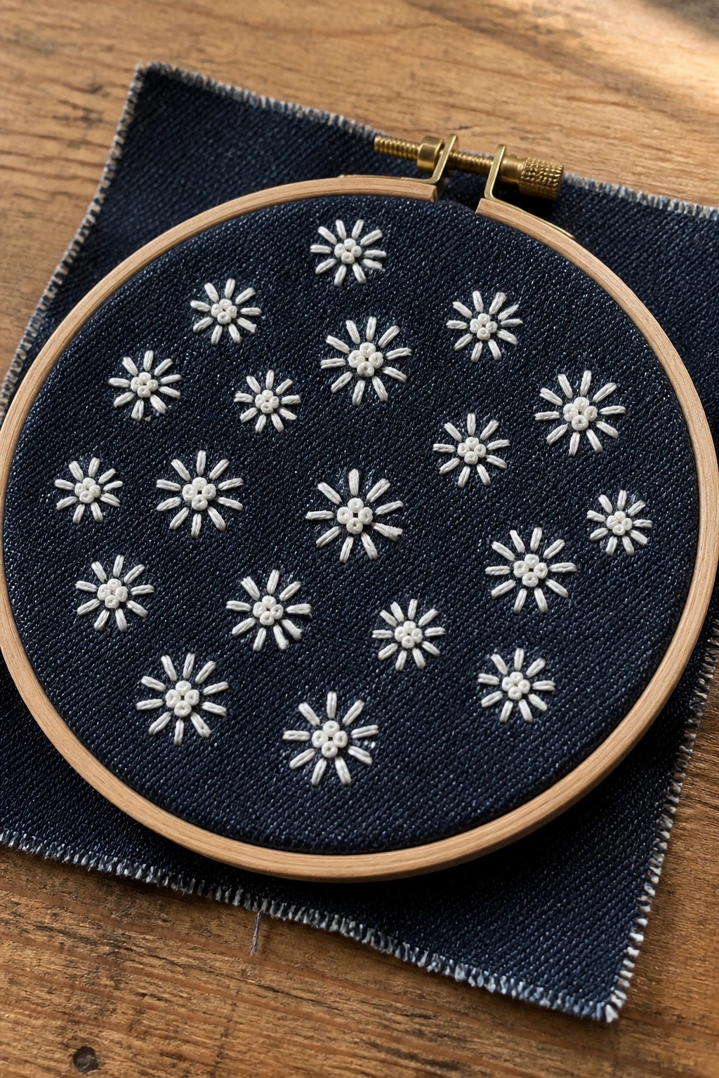 Wooden hoop with dark blue denim embroidered in scattered white flowers